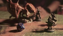 A Person Plays A Fantasy Roleplaying Game With Miniatures And Dice.