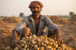 Indian farmer with a pile of fresh potatoes