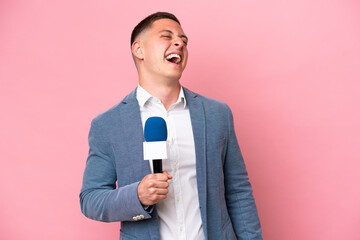 Wall Mural - Young brazilian presenter man isolated on pink background laughing