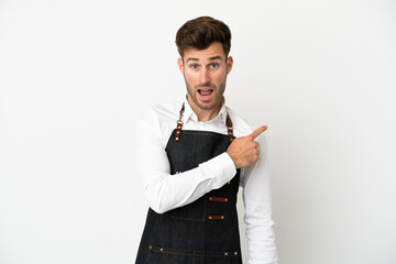 Poster - Restaurant caucasian waiter isolated on white background surprised and pointing side