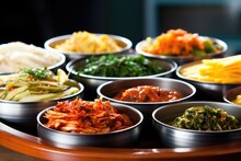 stack of various korean banchan dishes, focus on kimchi