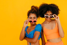 Multiracial Friends Wearing Sunglasses Against Yellow Background