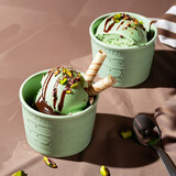 Lody pistacjowe  z polewą czekoladową na brązowym tle