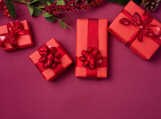 Wall Mural - Christmas decor, gifts wrapped in red paper on a red background, top view