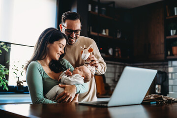 Wall Mural - Portrait of parents and newborn baby. Father and mother kiss and hug a beautiful newborn child. .