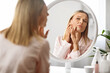 © Prostock-studio - Skin Problems. Upset Middle Aged Woman Looking At Pimples On Her Cheek