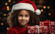 primo piano di dolce bambina con cappello natalizio , i mano pacchetti di natale, sfondo sfocato toni caldi e luci natalizie