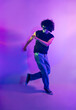 © ADDICTIVE STOCK - Energetic dance of latin man in neon-lit lilac background