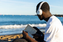 Young Man Reading By The Sea