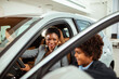 © Marko Geber - Joyful mother and son exploring a new car at a dealership