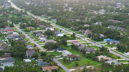 Wall Mural - Aerial view of rural street traffic with driving cars in small town. American suburban landscape with private homes in Florida quiet residential area