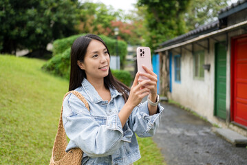 Sticker - Woman use mobile phone to take photo over the Taipei city background