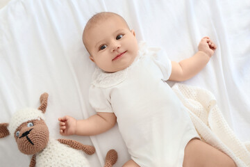 Canvas Print - Little cute baby with toy lying in crib at home