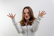 © Oleksandra - negative emotion of adolescence brain explosion girl with hands shows how it explodes in head experiences opens mouth waves hands boom strong explosion on a white background. emotional teenager
