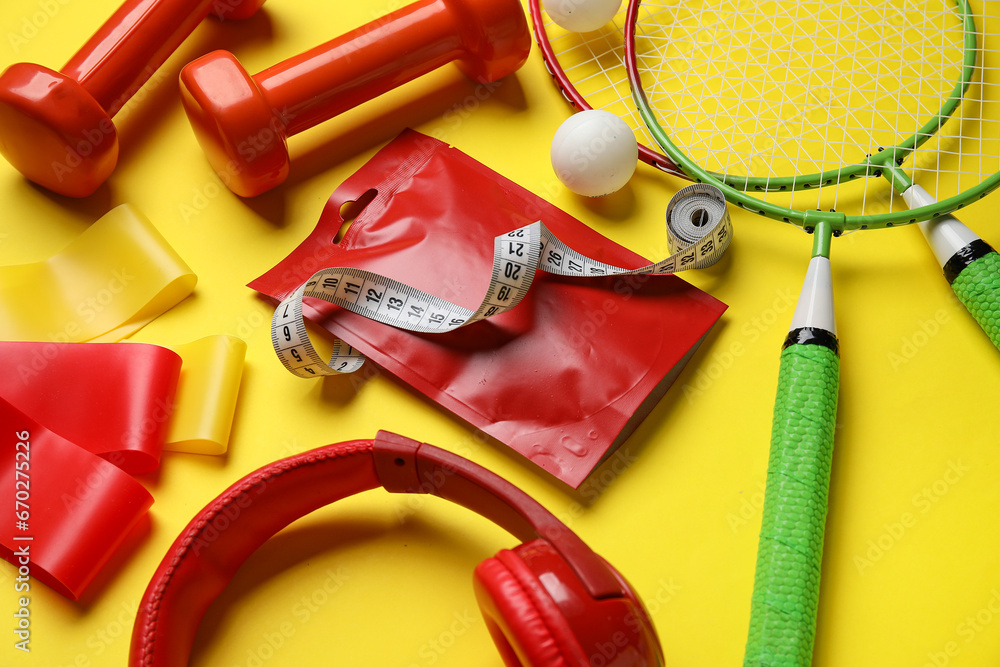 Composition with healthy snack and different sports equipment on yellow background
