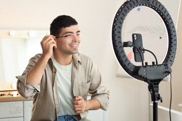 Canvas Print - Male beauty blogger with mascara recording video in makeup room