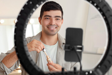 Sticker - Male beauty blogger with highlighter recording video in makeup room, closeup