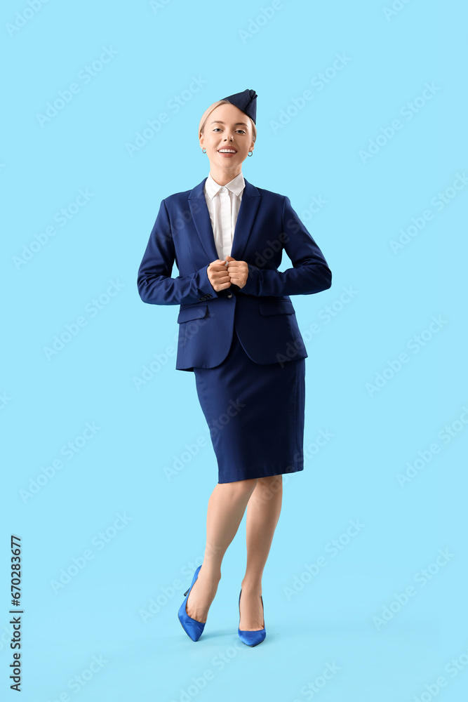 Young stewardess on blue background