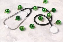 Christmas Composition With Stethoscope And Green Baubles On Grey Grunge Background