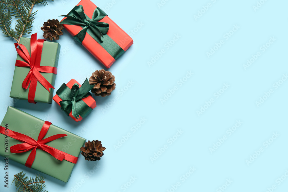 Christmas gift boxes with fir branches and pine cones on blue background