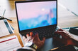 © BullRun - Back view of businessman sitting front open digital netbook