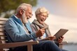 © sandra - elderly technology modern using computer tablet looking bench sitting couple active senior smiling woman old people happy laptop reading outdoors retirement home family mature book