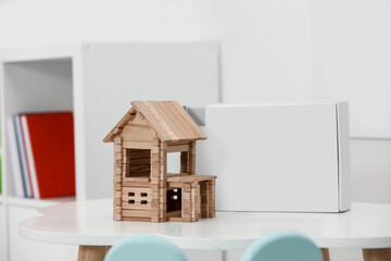 Wall Mural - Wooden house on white table indoors. Children's toy