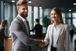 © vefimov - Professional man and woman shaking hands in office setting. This image can be used to represent business meetings, negotiations, teamwork, or collaboration in corporate environment.