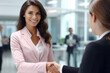 © vefimov - Professional woman shaking hands with man wearing suit. This image can be used to represent business meetings, negotiations, or partnerships.
