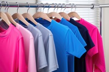 Alternating Pink And Blue T-shirts Hanging On A Rack