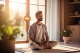 Fototapeta  - Healthy serene young man meditating at home, relaxing body and mind sitting on floor in living room. Mental health and meditation for no stress.