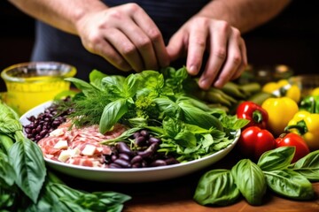 Canvas Print - hand plucking fresh basil leaves over a nicoise salad