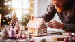 Man decorating gingerbread house with icing sugar. Man makes a cake in the shape of a house for New Year and Christmas. Family preparation holiday food.