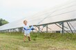 © Serhii - Little happy boy playing with toy airplane near solar panels.
