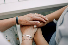 Midsection Of Senior Man And Female Nurse Holding Hands At Retirement Home