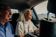 © Maskot - Cheerful senior couple enjoying taxi ride in city