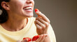 Happy young woman eating red grape tomatoes. Female eats cherry tomatoes.