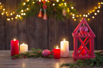 Wall Mural - wooden lantern with candles and Christmas branchs on wooden background