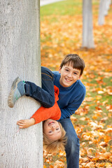 Wall Mural - Cute blond child, boy, playing with knitted toys in the park, autumntime