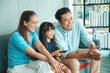 © aekkorn - Happy Asian family lifestyle enjoy watching TV in living room at home. Happy Asian family portrait with mother, father and daughter.