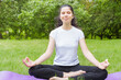 © ibragimova - a young girl sits in nature in a lotus field, a girl does yoga in nature on a mat
