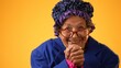 Funny closeup view of smiling happy elderly senior old woman with wrinkled skin smiling with hands together isolated on solid yellow background.