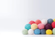 colorful yarn balls pile on white background with copy space
