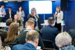 © Anton Gvozdikov - Businesswoman giving presentation to male and female colleagues at conference at export forum