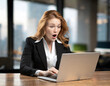 © masterofmoments - surprised businesswoman working on laptop