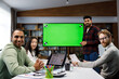 © YURII MASLAK - Marketing strategy analysis, stock market trading or corporate teamwork. A team of startups at a table with a large green screen TV. Mixed race business team.