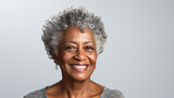 This close-up studio photo features a senior African American woman with grey hair, isolated on a white background, highlighting her elegance and character.
