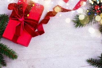 Poster - Christmas gift giving flat lay scene - christmas present box in red box on white wooden table with bokeh