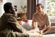Portrait of young African American couple enjoying conversation in morning in cozy home, everyday life