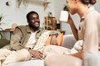 Portrait of young African American couple talking joyfully in morning in cozy home, everyday life